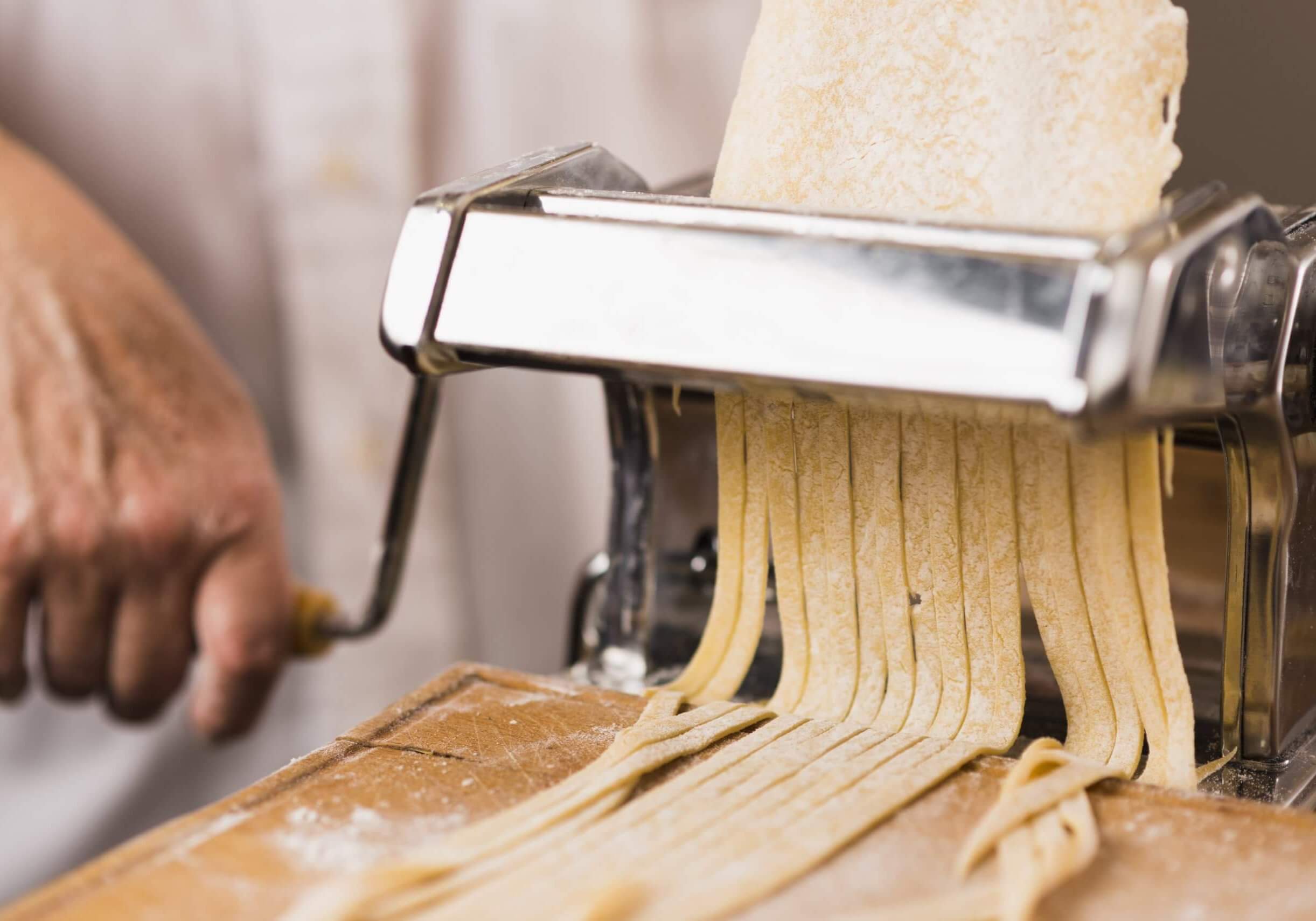 close-up-person-cutting-pasta