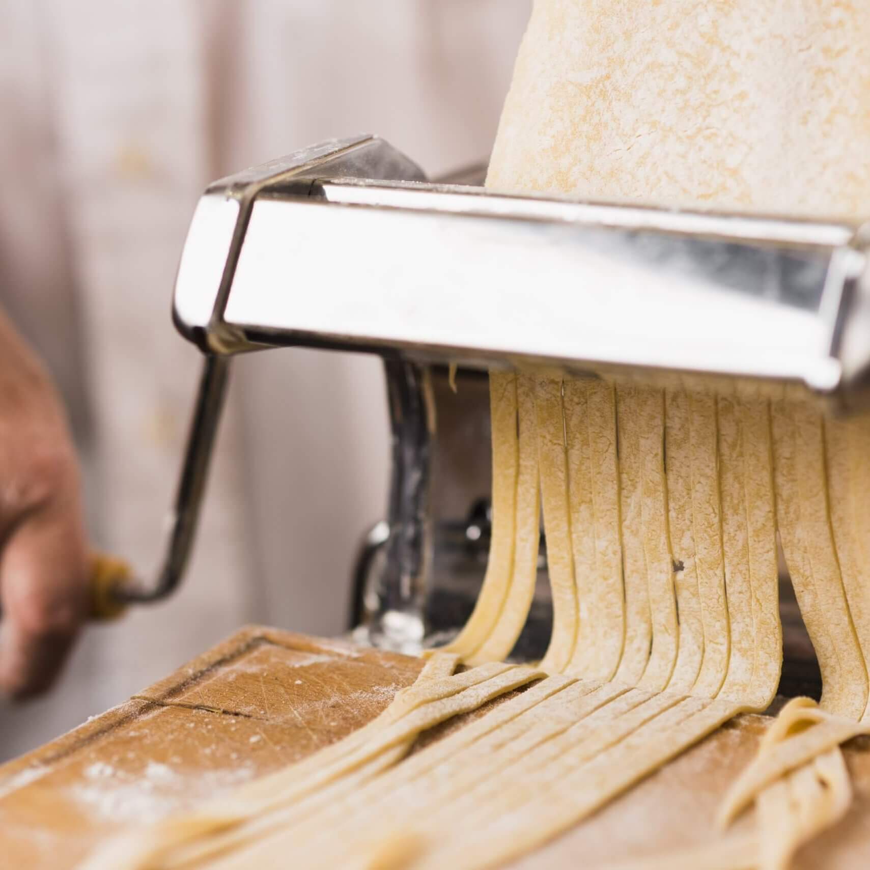 close-up-person-cutting-pasta