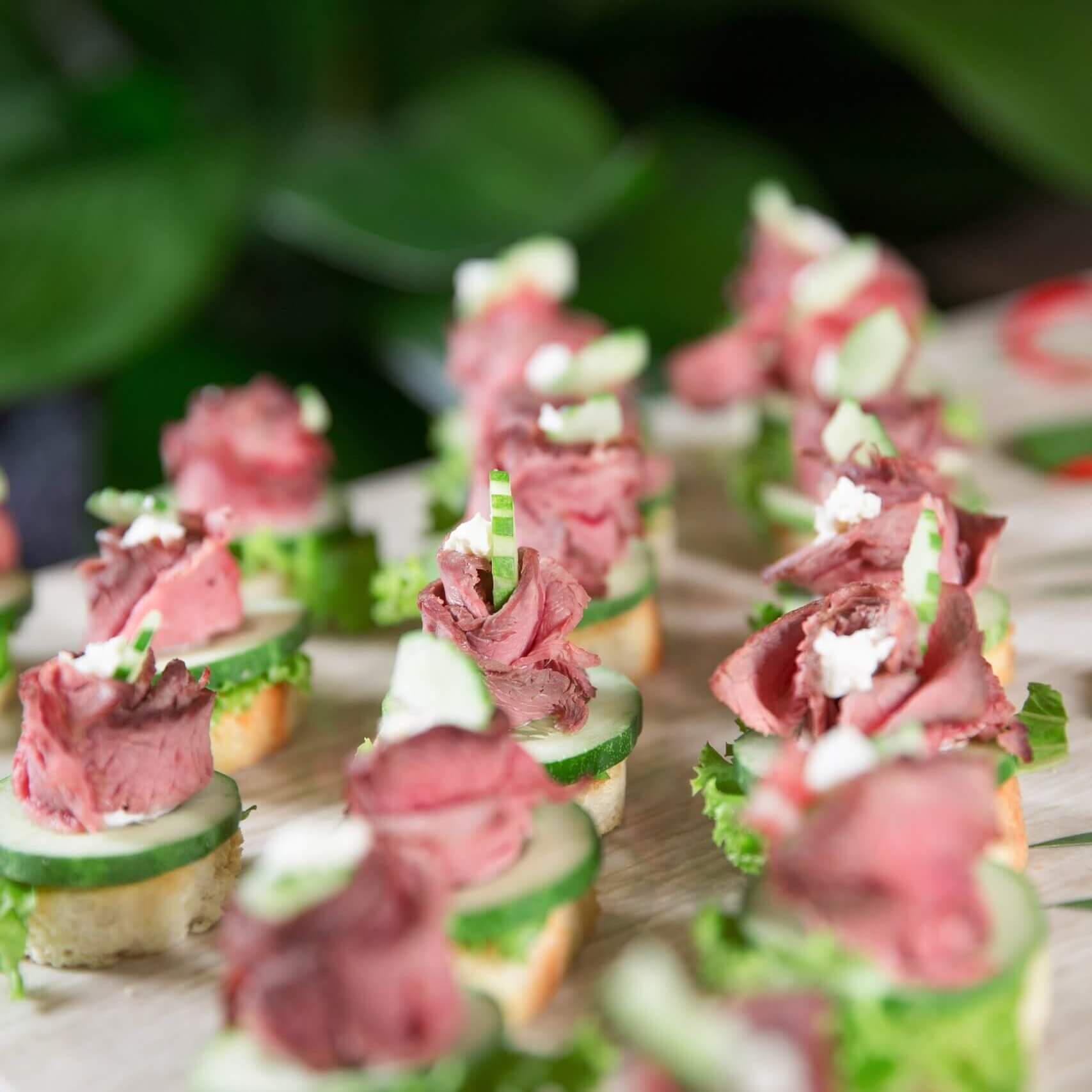 Delicious mini canapes with meat and cucumber on buffet table. Catering concept