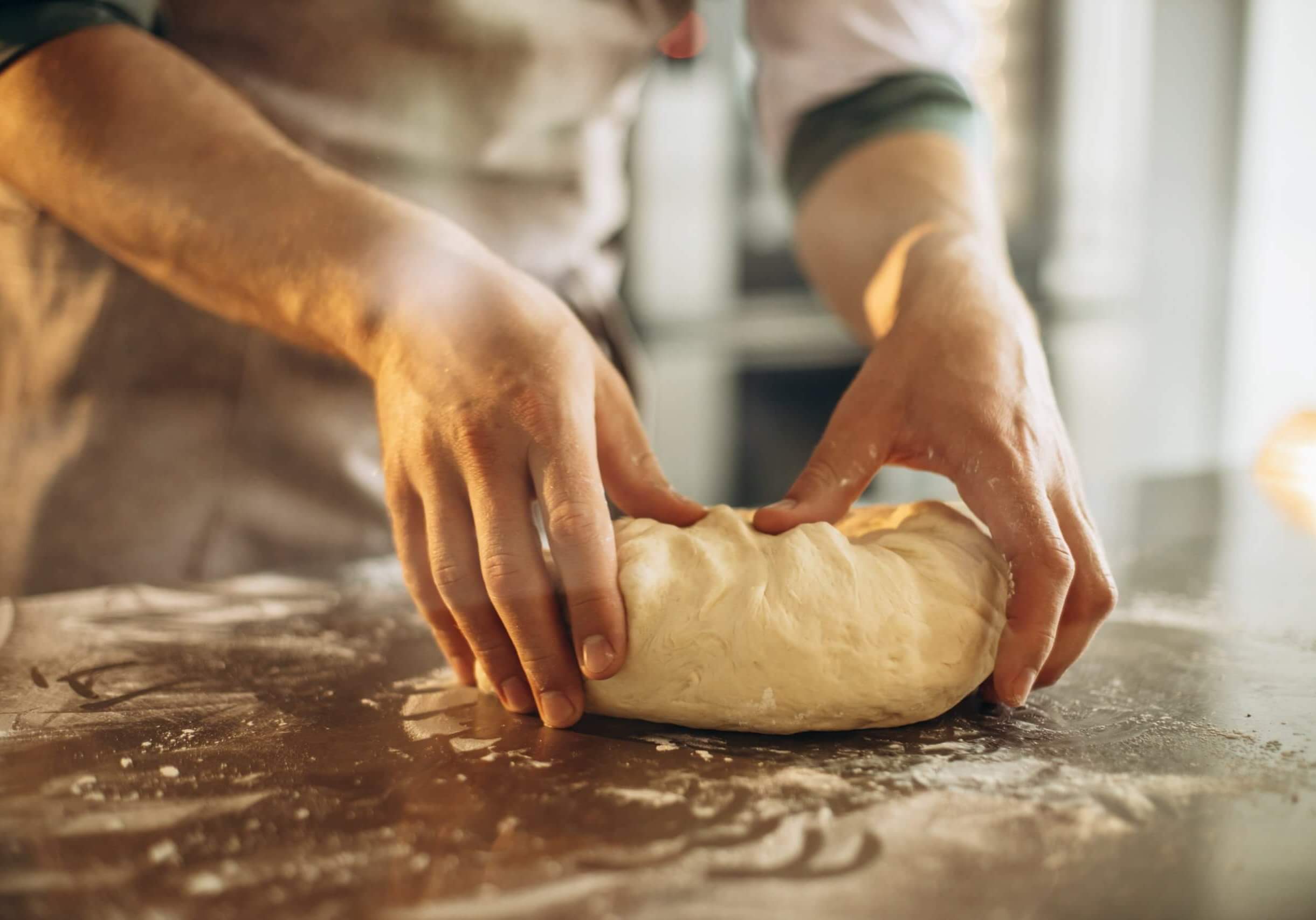 Man kneads the dough for bread